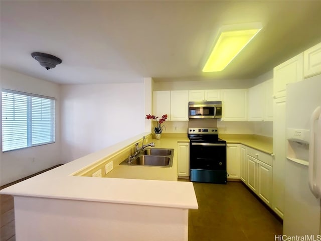 kitchen featuring kitchen peninsula, sink, white cabinets, and appliances with stainless steel finishes