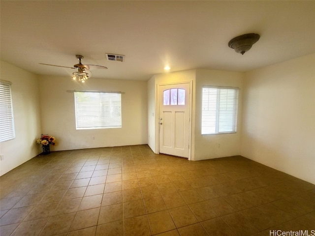 foyer with ceiling fan and light tile patterned flooring