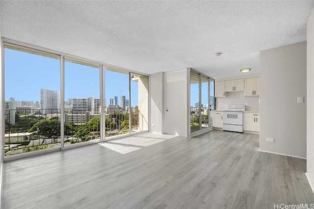 unfurnished living room with expansive windows, a textured ceiling, and light hardwood / wood-style flooring