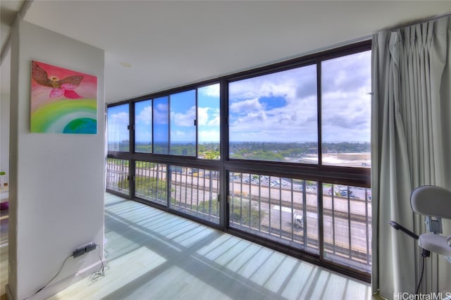 interior space with hardwood / wood-style floors, a healthy amount of sunlight, and floor to ceiling windows