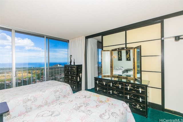 bedroom with carpet flooring, expansive windows, and a water view