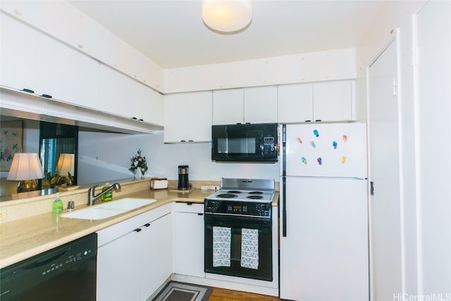 kitchen with sink, white cabinets, black appliances, and light hardwood / wood-style flooring