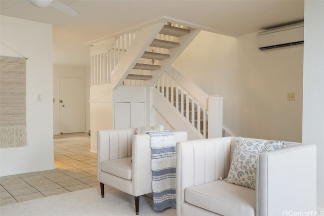 living area featuring tile patterned floors, ceiling fan, and a wall mounted AC