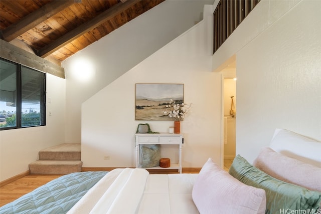 bedroom with lofted ceiling with beams, light hardwood / wood-style floors, and wooden ceiling