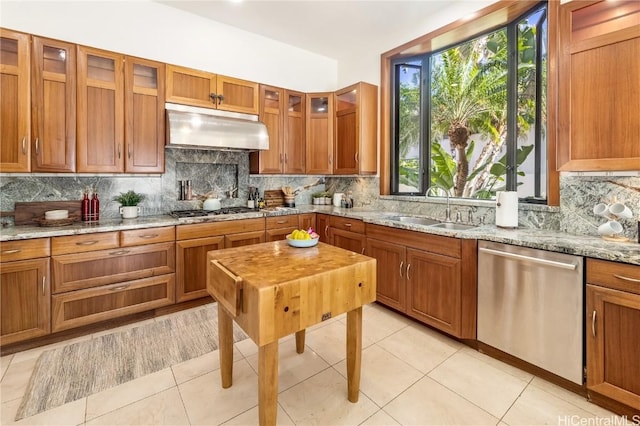 kitchen featuring sink, stainless steel appliances, light stone counters, decorative backsplash, and light tile patterned floors