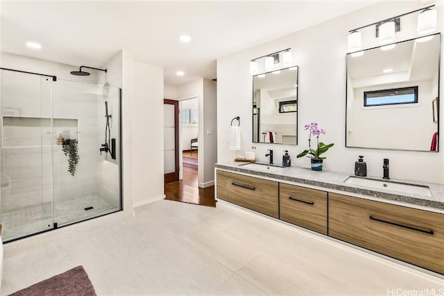 bathroom featuring hardwood / wood-style floors, vanity, and walk in shower