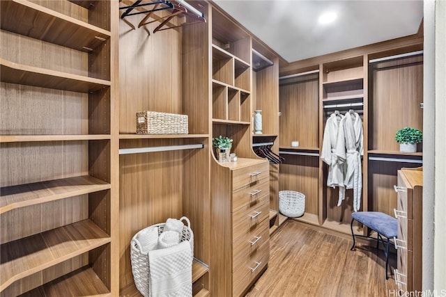 walk in closet with light hardwood / wood-style floors