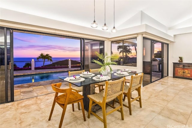 dining space with a water view and lofted ceiling