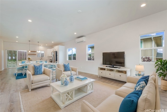 living room featuring light wood-type flooring and an AC wall unit