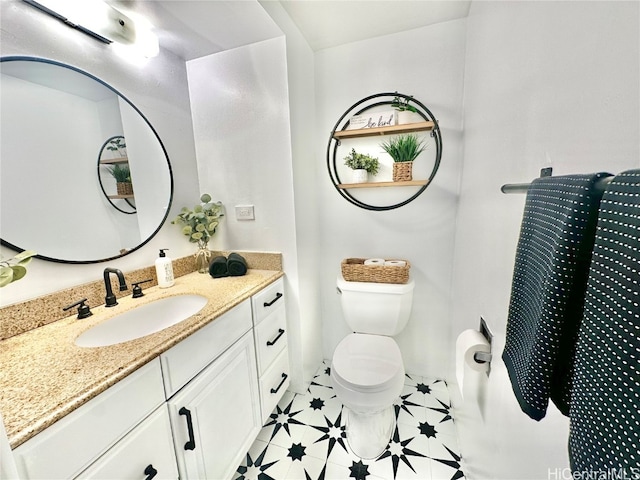 bathroom featuring tile patterned flooring, vanity, and toilet