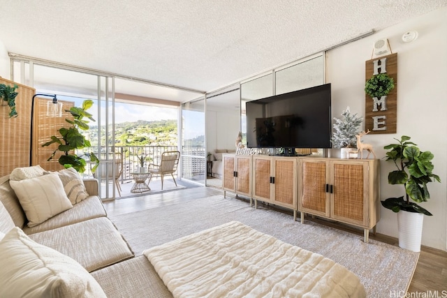 living room featuring a wall of windows, a textured ceiling, and hardwood / wood-style flooring