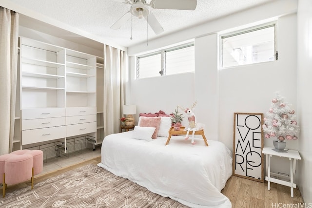 bedroom featuring a textured ceiling, light hardwood / wood-style floors, and ceiling fan