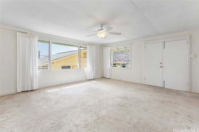 carpeted spare room with ceiling fan