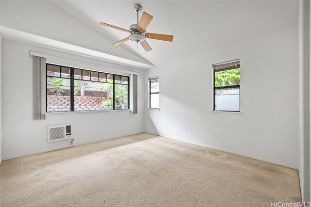 carpeted spare room with a wall unit AC, a wealth of natural light, lofted ceiling, and ceiling fan