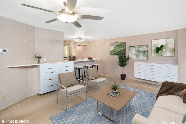 living room with ceiling fan with notable chandelier