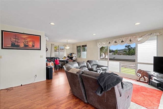 living room with hardwood / wood-style floors, an inviting chandelier, and a healthy amount of sunlight