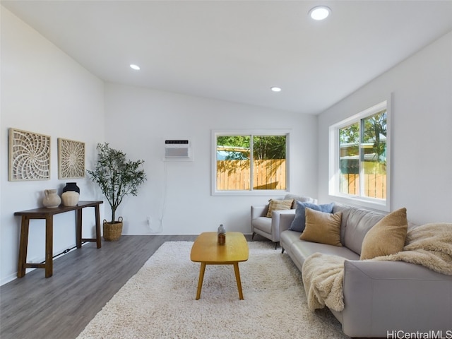 living room with a wall mounted air conditioner, dark hardwood / wood-style flooring, plenty of natural light, and lofted ceiling