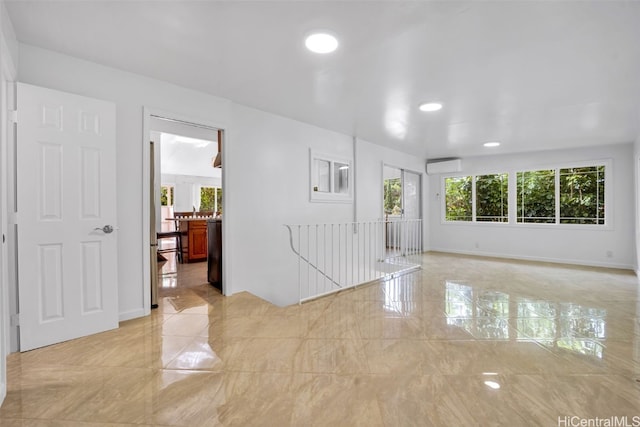 empty room with a wall unit AC and plenty of natural light