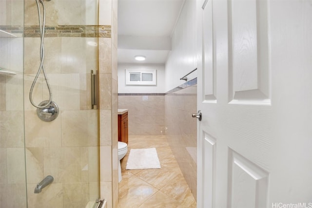 bathroom featuring walk in shower, tile patterned flooring, toilet, vanity, and tile walls