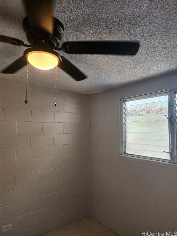 unfurnished room with a textured ceiling and ceiling fan