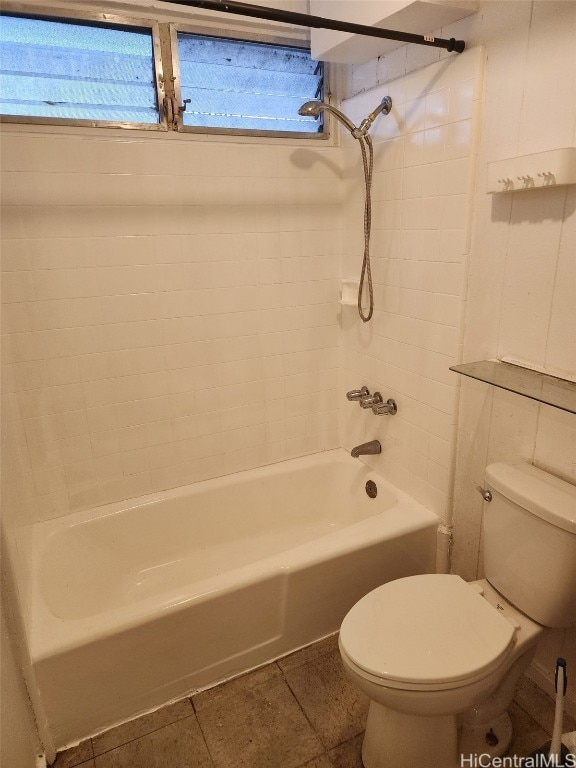 bathroom featuring toilet, tiled shower / bath combo, tile patterned floors, and a healthy amount of sunlight