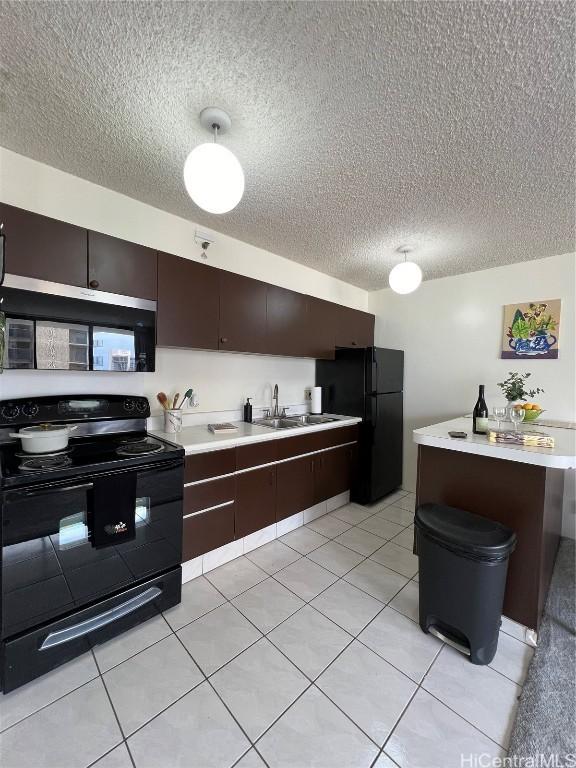 kitchen with dark brown cabinets, light tile patterned floors, black appliances, and sink