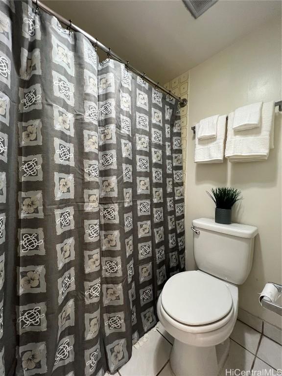 bathroom with walk in shower, tile patterned flooring, and toilet