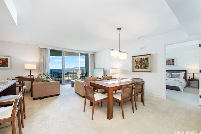 dining space with expansive windows and light carpet