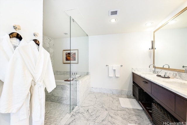 bathroom featuring vanity and a relaxing tiled tub