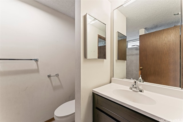 bathroom featuring vanity, toilet, and a textured ceiling