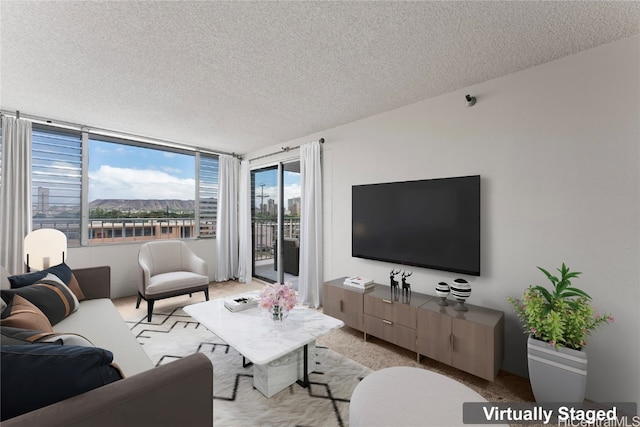 living room with a textured ceiling, light colored carpet, and a wall of windows