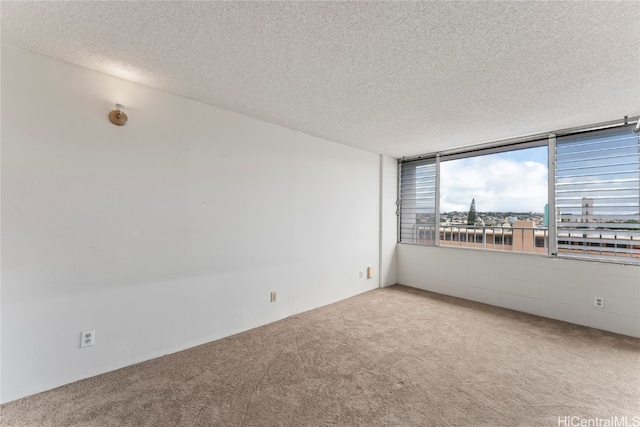 carpeted empty room with a textured ceiling