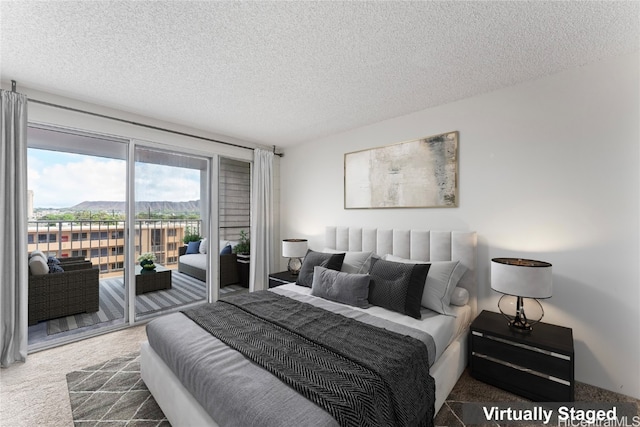 bedroom featuring access to exterior, dark carpet, and a textured ceiling