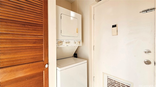 clothes washing area with stacked washer and dryer