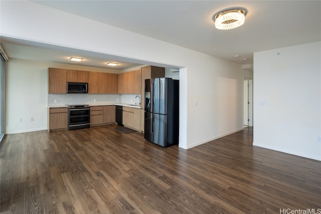 kitchen with black appliances, dark hardwood / wood-style floors, sink, and backsplash