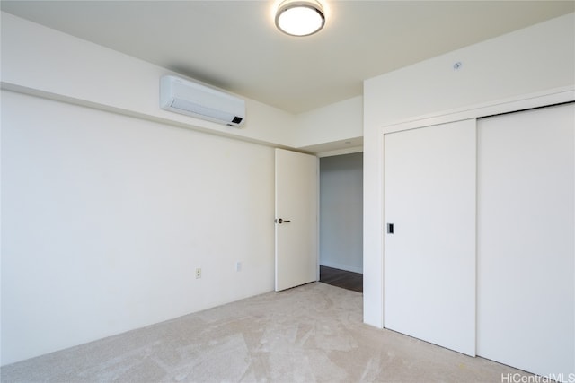 unfurnished bedroom with light carpet, a wall unit AC, and a closet