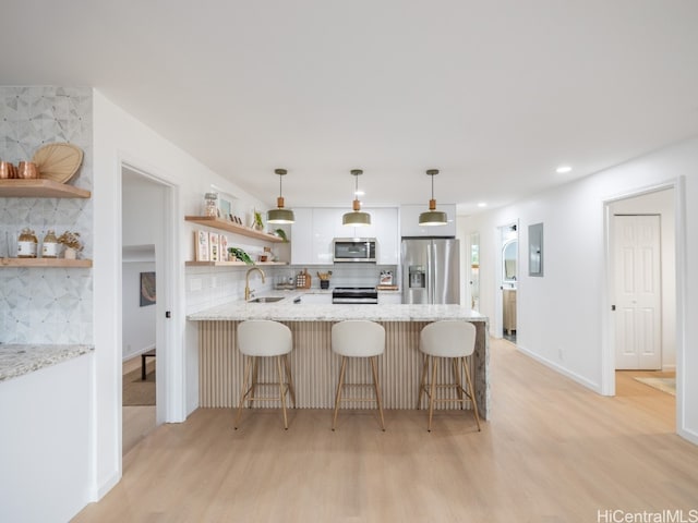 kitchen featuring a breakfast bar, light stone countertops, stainless steel appliances, and tasteful backsplash