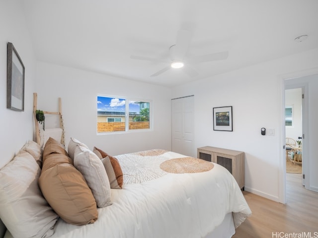 bedroom featuring ceiling fan, light hardwood / wood-style floors, and a closet