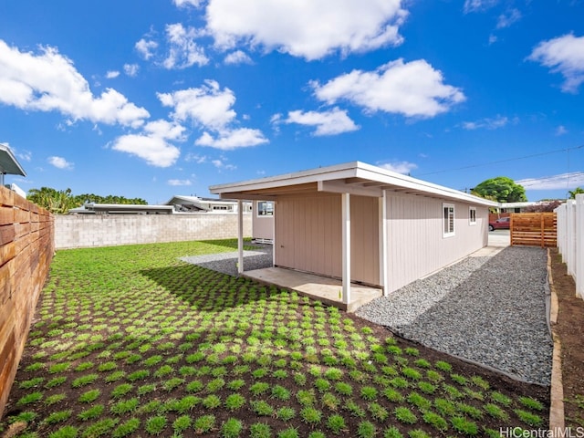 back of house featuring a lawn and a patio area