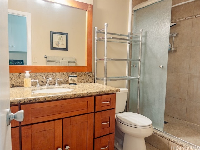 bathroom featuring vanity, tasteful backsplash, toilet, and an enclosed shower