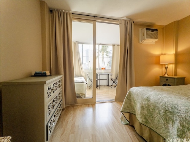 bedroom featuring light hardwood / wood-style flooring and a wall unit AC