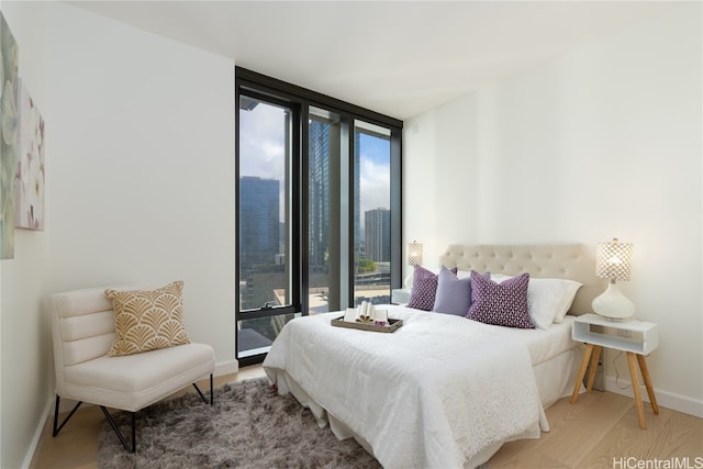 bedroom featuring expansive windows and wood-type flooring