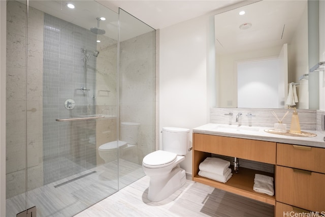 bathroom featuring vanity, a shower with shower door, and toilet