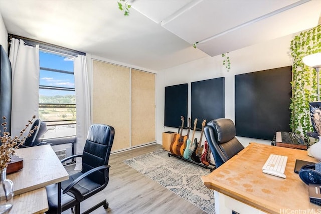 home office featuring light wood-type flooring and floor to ceiling windows