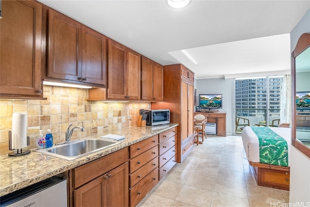 kitchen featuring backsplash, sink, light tile patterned floors, and stainless steel appliances