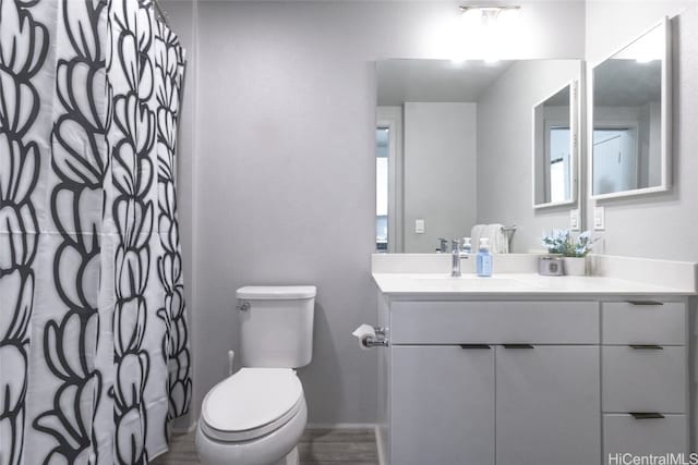 bathroom with a shower with shower curtain, vanity, and toilet