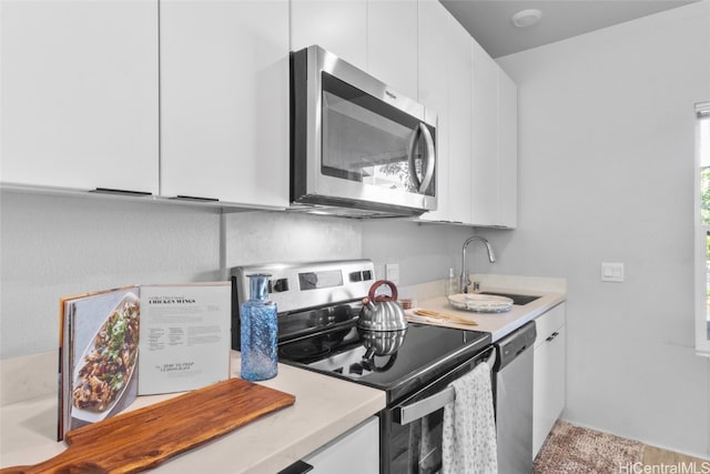 kitchen with sink, white cabinets, and stainless steel appliances