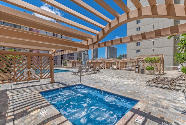 view of pool featuring a community hot tub, a patio, and a pergola