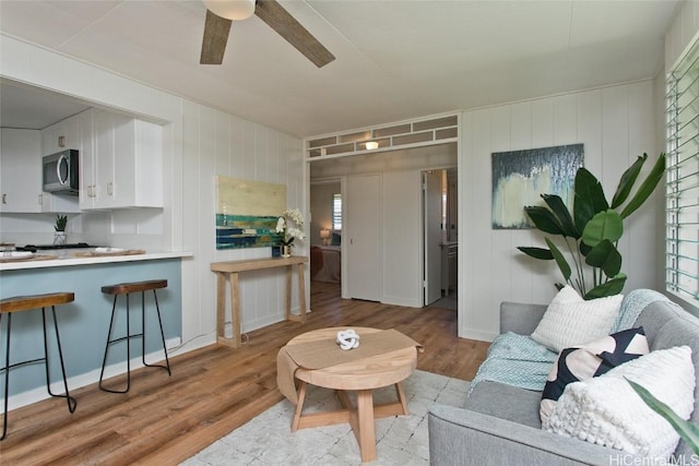 living room featuring ceiling fan and light hardwood / wood-style flooring