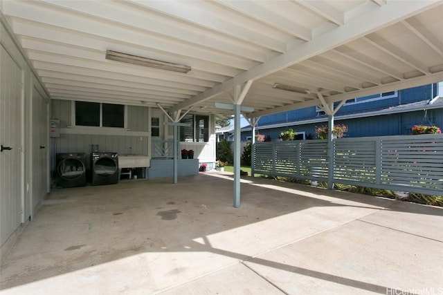 view of parking / parking lot with washer and dryer and a carport